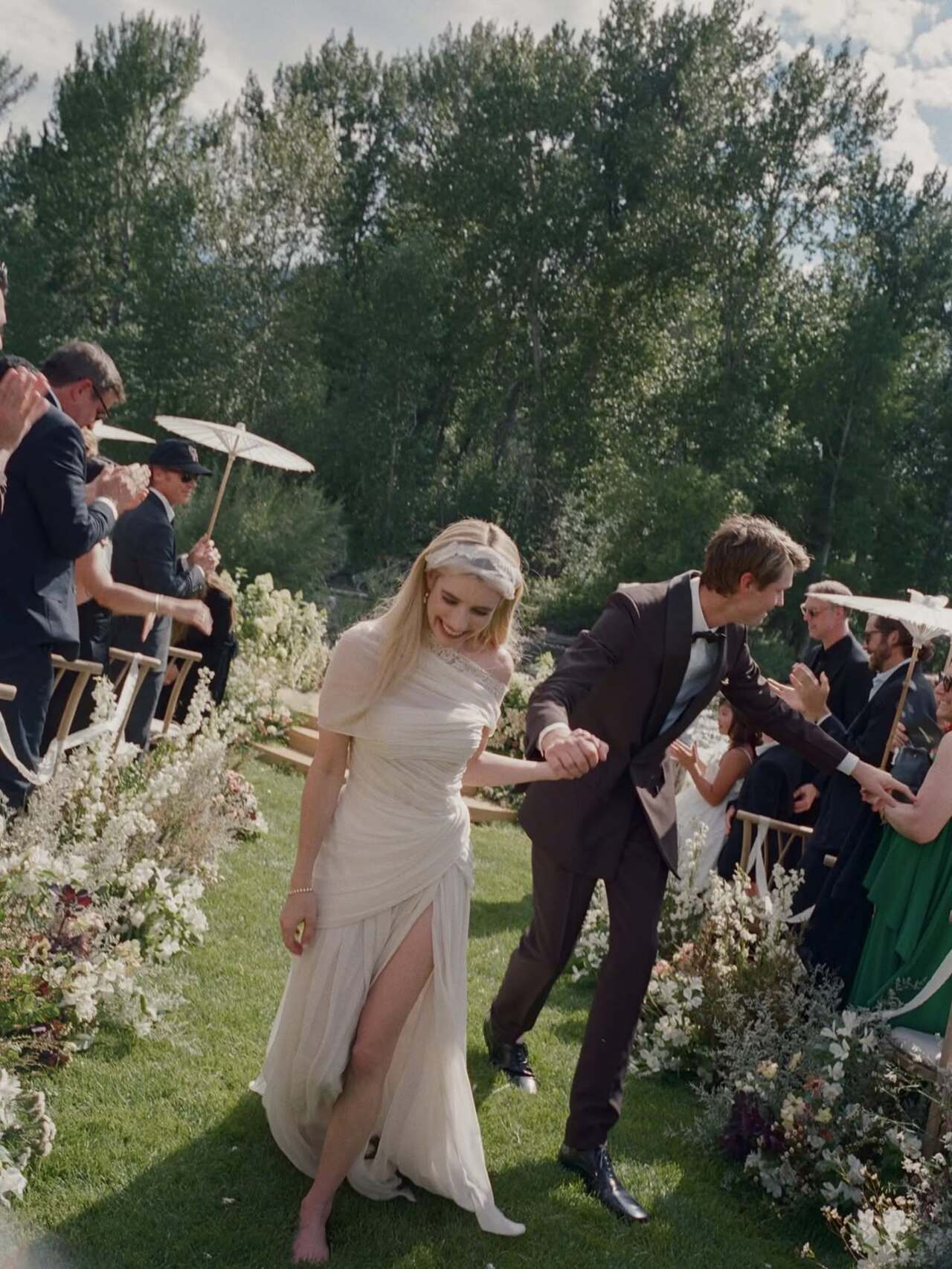Emma chose a custom Monique Lhuillier gown in an antique ivory shade instead of traditional white, embracing a timeless aesthetic for her big day